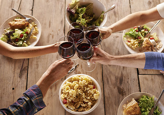 Shot of people toasting with wine over a meal