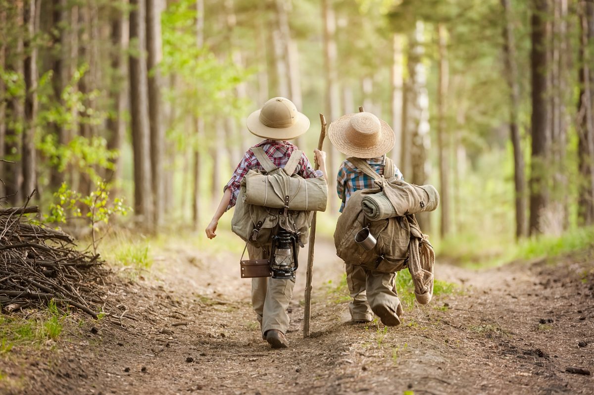 Boy on a fore t road with backpack